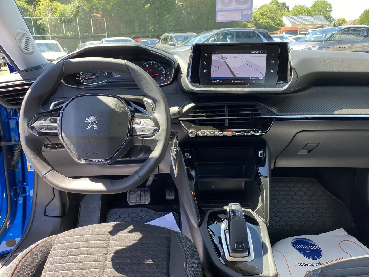 Intérieur avant du Peugeot 2008 bleu Vertigo, volant multifonction, écran tactile 7 pouces avec navigation affichée.