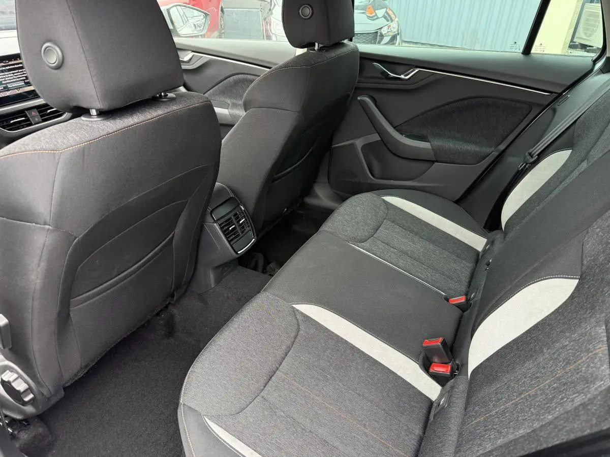 Vue intérieure arrière côté droit du Skoda Kamiq 2022, sièges tissu gris avec inserts clairs et appuie-tête.