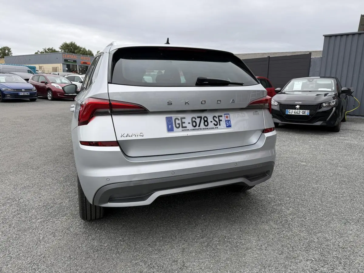 Vue arrière d'un Skoda Kamiq gris métallisé avec plaques françaises, feux arrière LED et diffuseur gris platine.