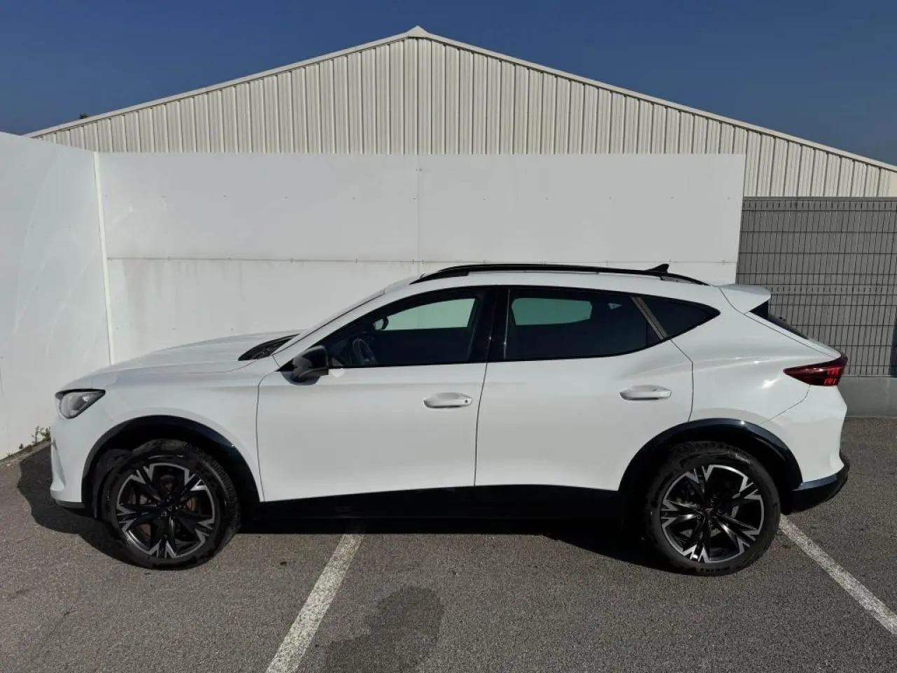 Vue de profil côté gauche du CUPRA Formentor blanc nacré avec toit noir et jantes alliage noires 18 pouces.