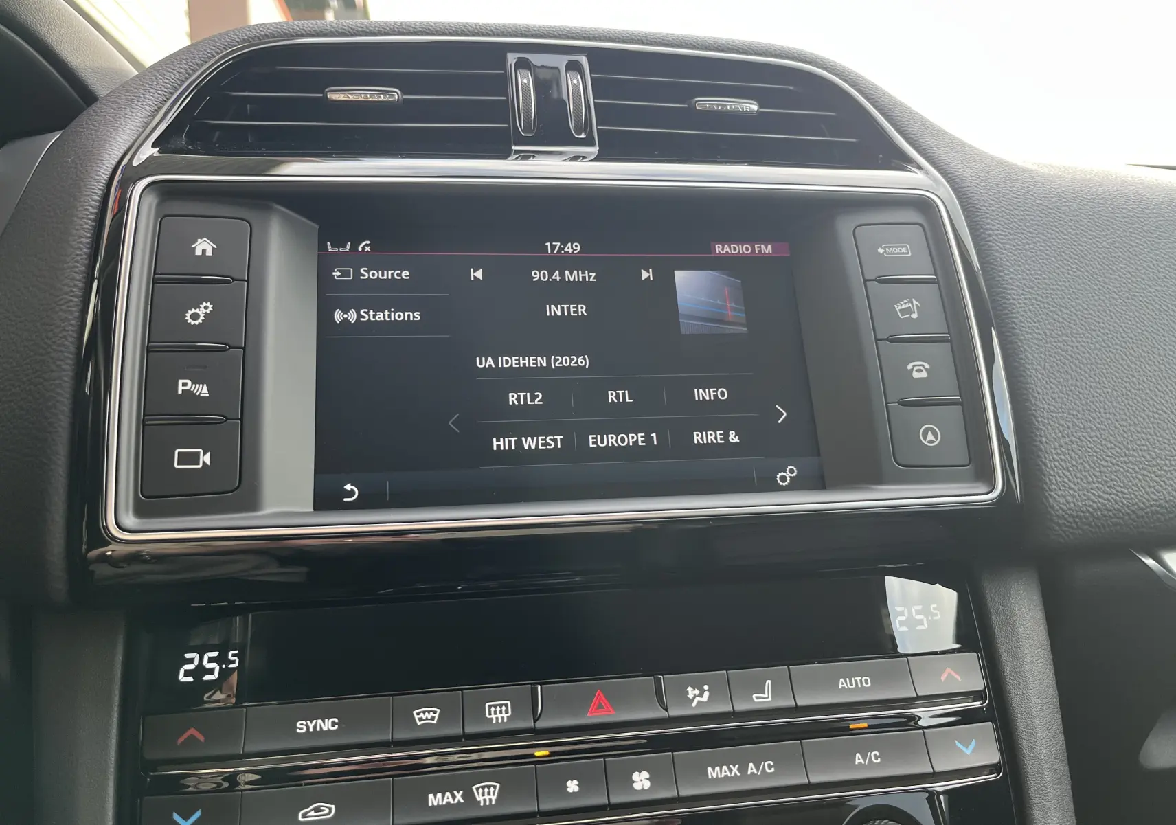 Vue rapprochée de l’écran central tactile et de la console de climatisation du Jaguar F-PACE blanc, version 240D Prestige 2018.