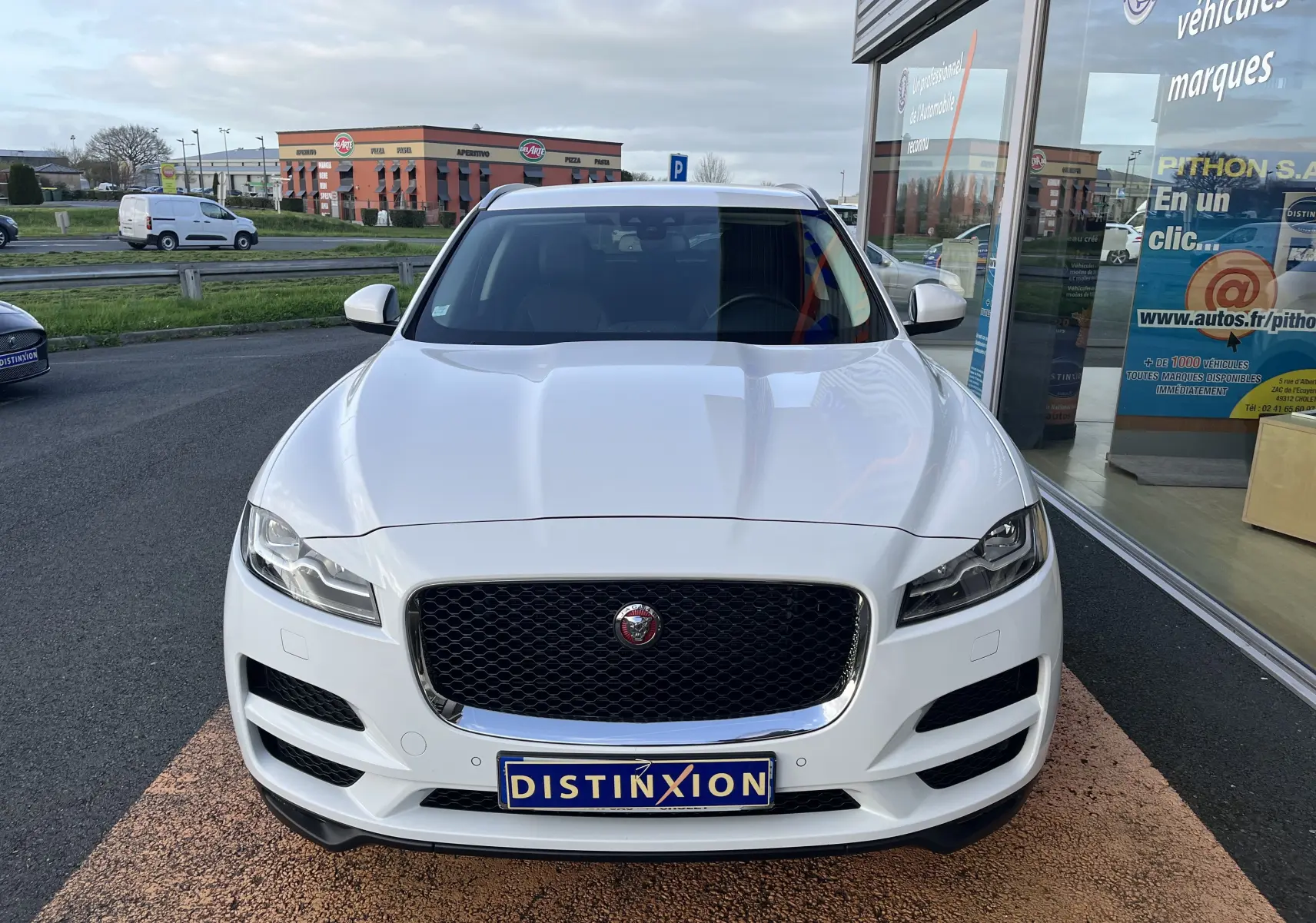 Jaguar F-PACE blanc vue de face, mettant en valeur la calandre noire et les phares LED distinctifs.