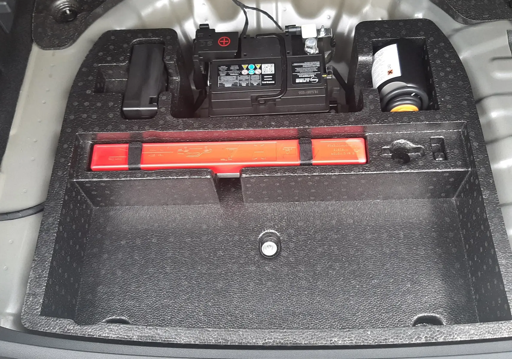 Vue plongeante sur le compartiment de rangement arrière du MG MOTOR ZS Camden Grey 2026, montrant batterie et kit de sécurité.