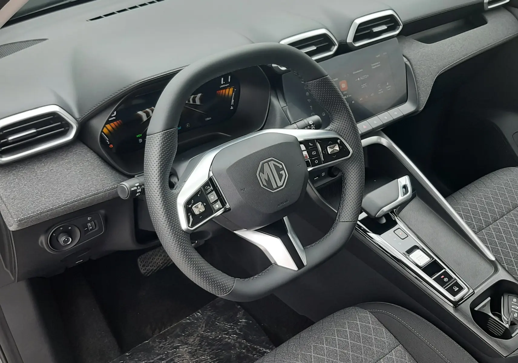 Vue intérieure côté conducteur du MG ZS 1.5 Hybrid+ 2026, volant multifonction, tableau de bord numérique et sellerie grise.