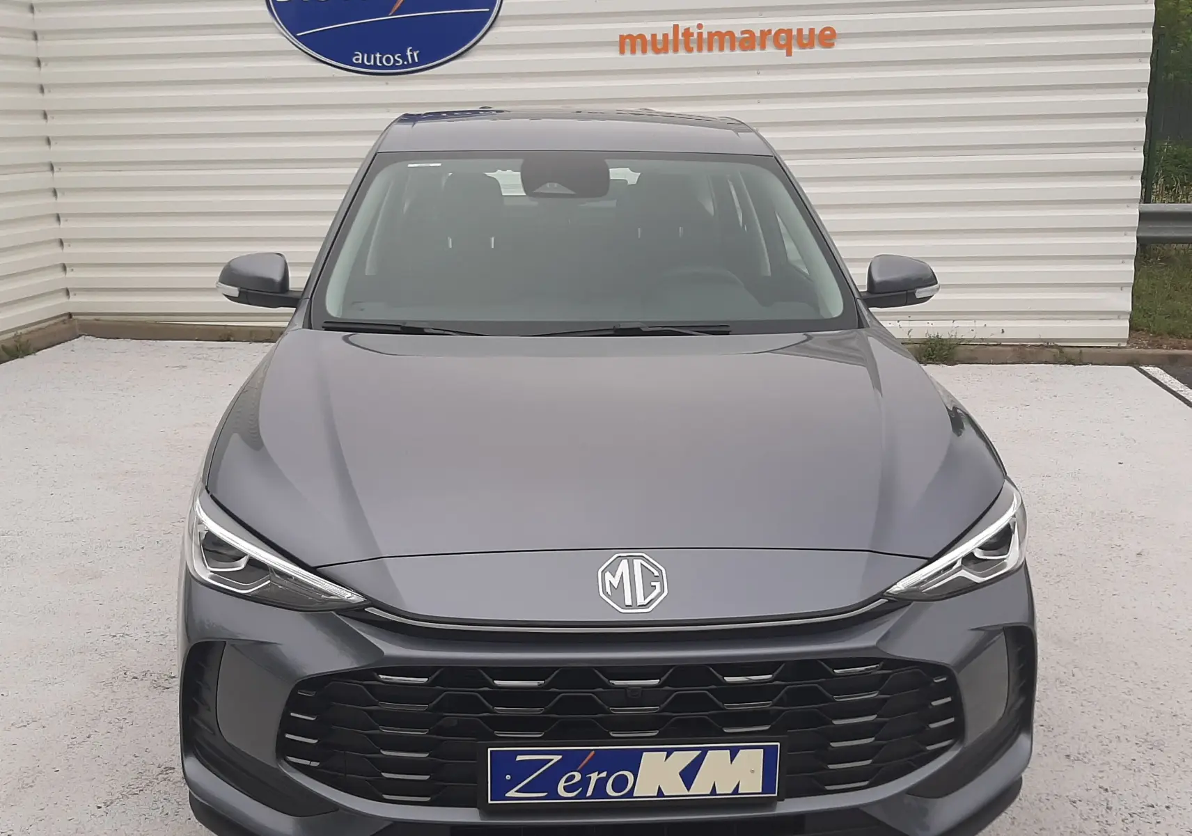 Vue avant du MG ZS 1.5 Hybrid+ 197ch en Camden Grey avec calandre noire et logo MG centré.