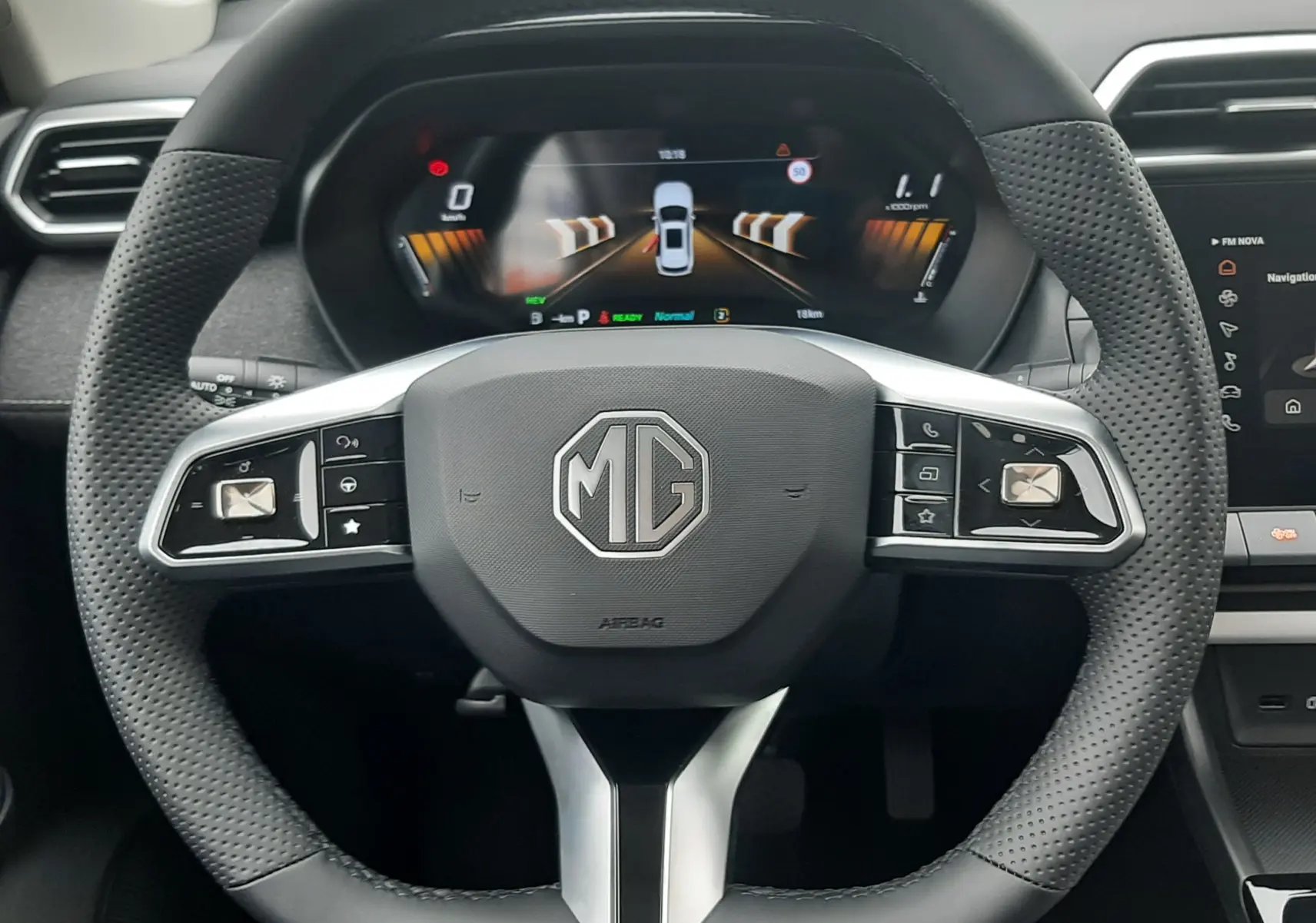 Vue rapprochée du volant perforé et du tableau de bord numérique du MG MOTOR ZS 1.5 HYBRID+ 197CH en Camden Grey.