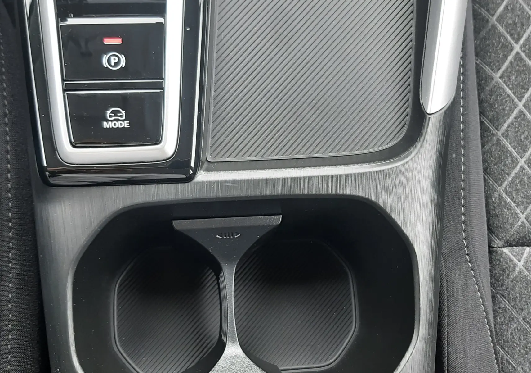 Gros plan sur la console centrale noire du MG ZS Camden Grey 2026, avec porte-gobelets et boutons de mode de conduite.