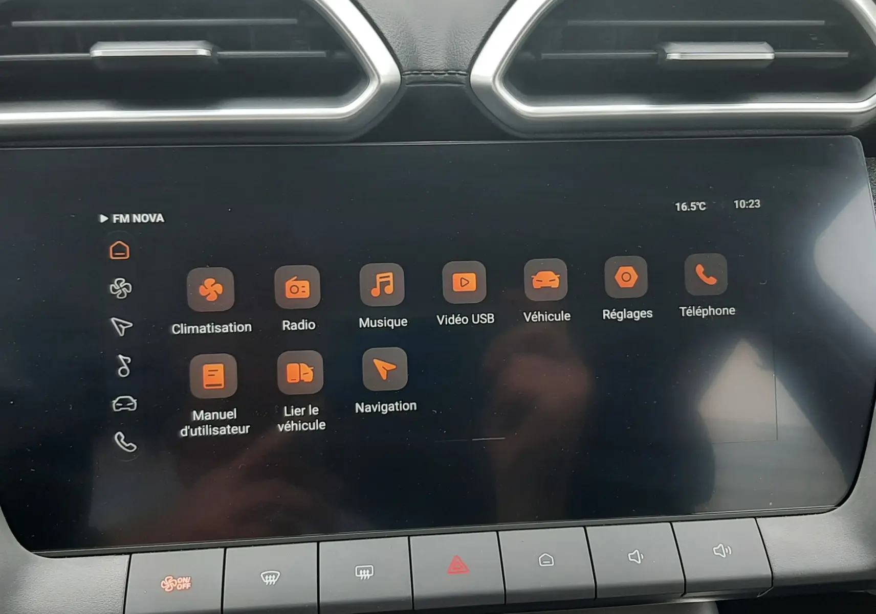 Écran tactile central du MG Motor ZS 1.5 Hybrid+ 2026 avec interface orange et aérateurs hexagonaux en haut.
