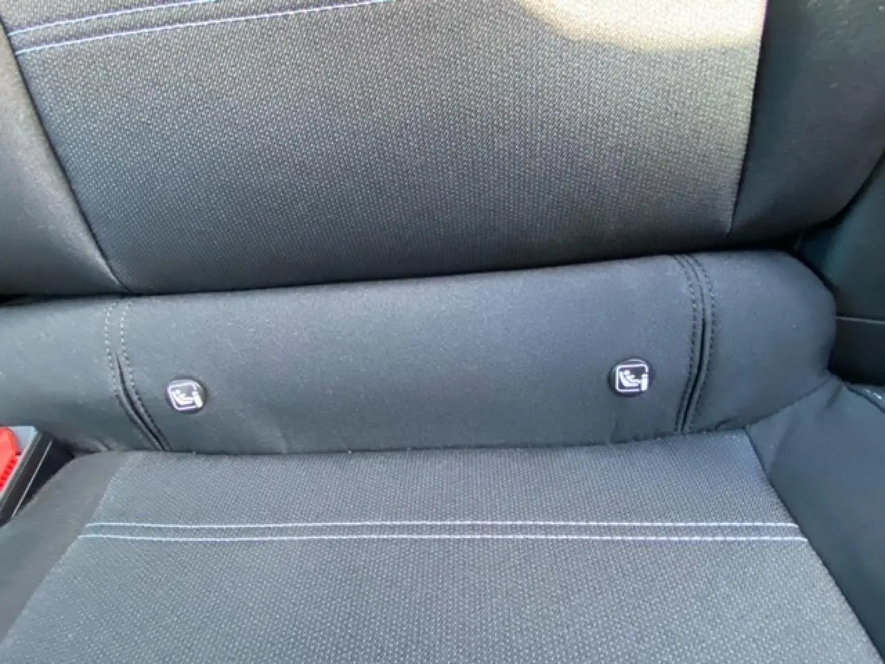 Détail des fixations ISOFIX sur la banquette arrière en tissu gris foncé de la Dacia Logan 2022.