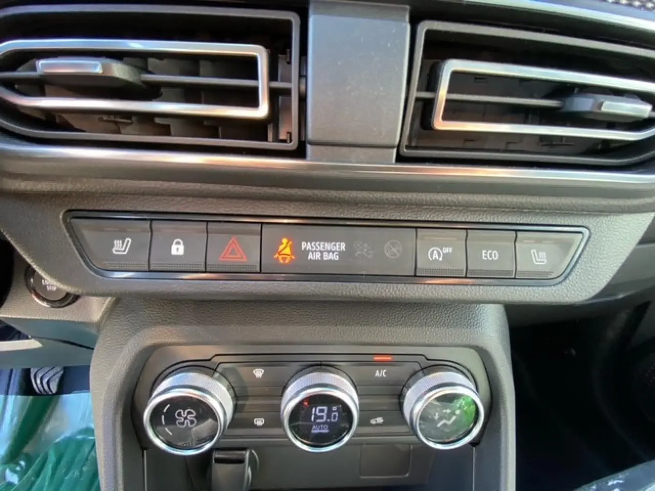 Vue rapprochée du tableau de bord de la Dacia Logan 2022, montrant la climatisation automatique et les commandes centrales.