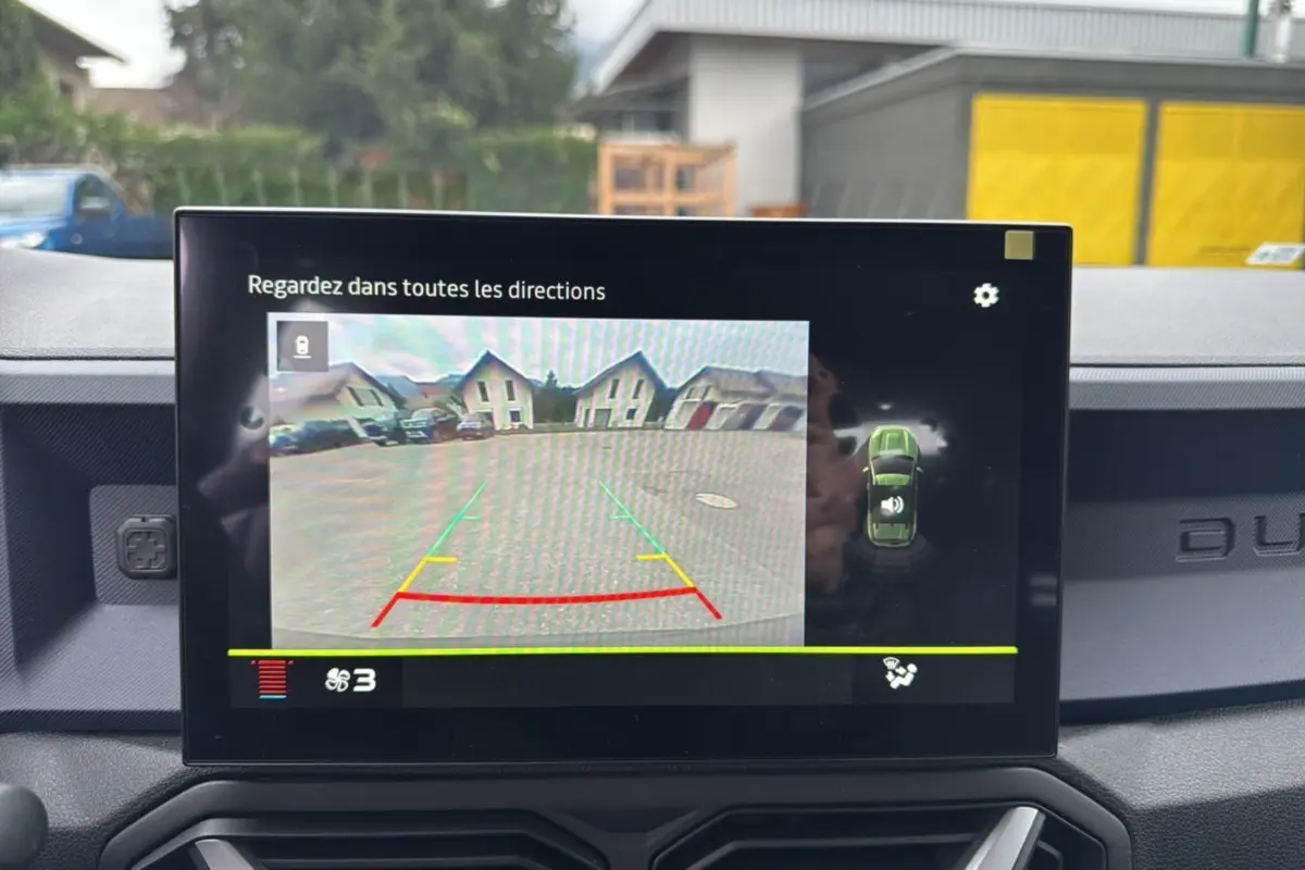 Écran central du Dacia Duster 2025 montrant la caméra de recul avec guidage de trajectoire en gris schiste.