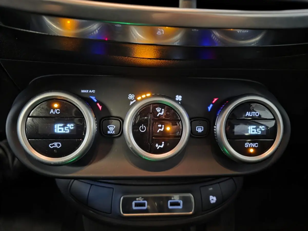 Gros plan sur la commande de climatisation automatique bi-zone de la Fiat 500X rouge, avec affichage digital à 16,5°C.