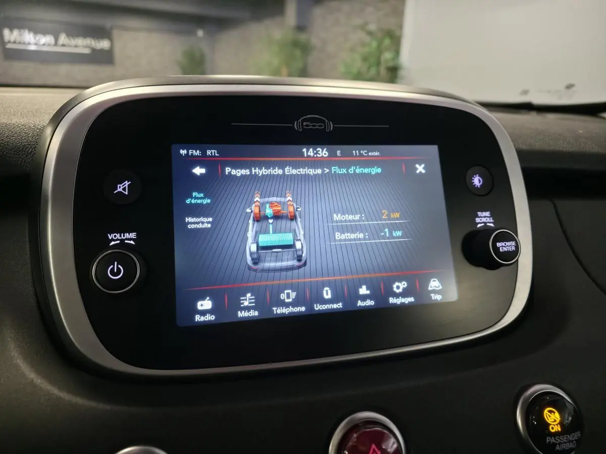 Écran tactile central du tableau de bord du Fiat 500X rouge 2024 affichant le flux d'énergie hybride.