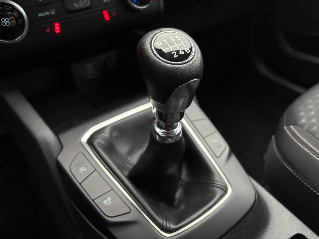 Le levier de vitesses manuel du Ford Kuga 2024 en cuir noir, vu de près au centre de la console.