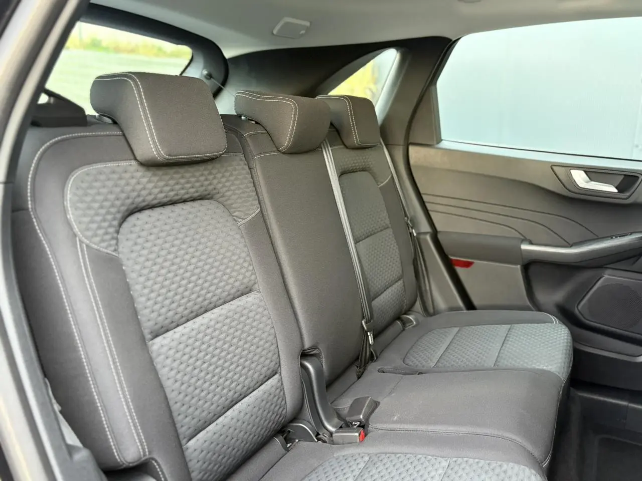 Vue latérale droite des sièges arrière gris foncé du Ford Kuga 2024, soulignant la texture et les appuie-têtes réglables.