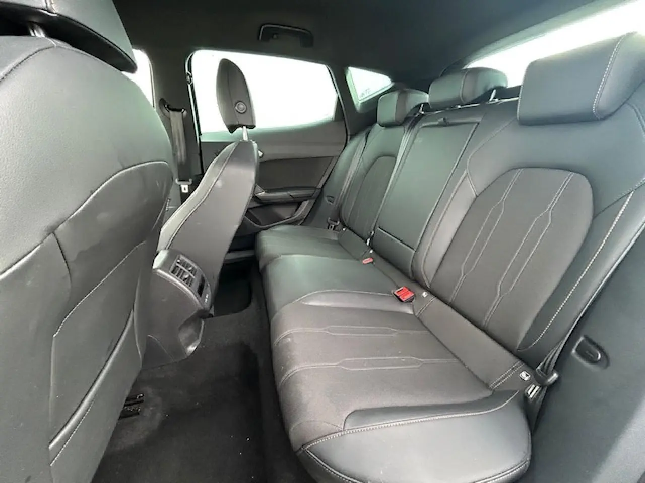 Vue intérieure côté droit des sièges arrière en cuir noir du CUPRA Formentor 2025 avec finitions sobres et appuie-têtes intégrés.