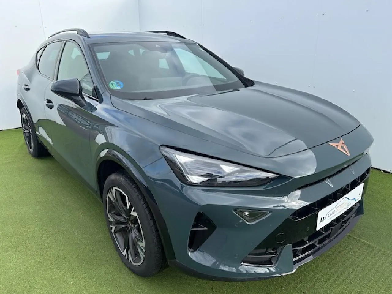 Vue 3/4 avant gauche d'un CUPRA Formentor gris Fiord Metal avec jantes alliage 18'' Sonora et logo CUPRA cuivré sur le capot.