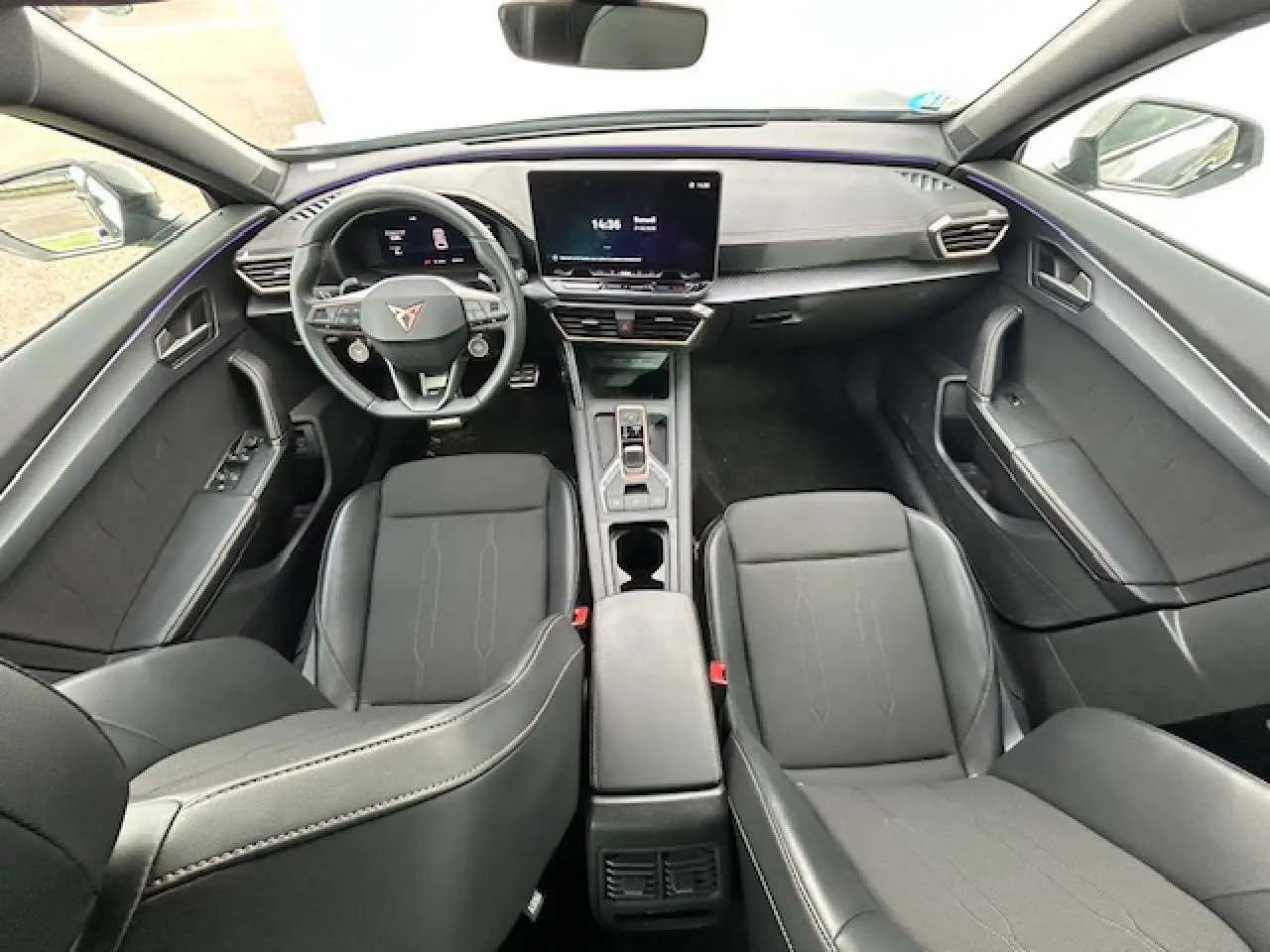 Vue intérieure avant du CUPRA Formentor 2025 avec sièges noirs, volant cuir et écran tactile central.