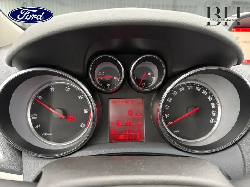 Vue rapprochée du tableau de bord avec compte-tours, jauge de température et vitesse, éclairage rouge.