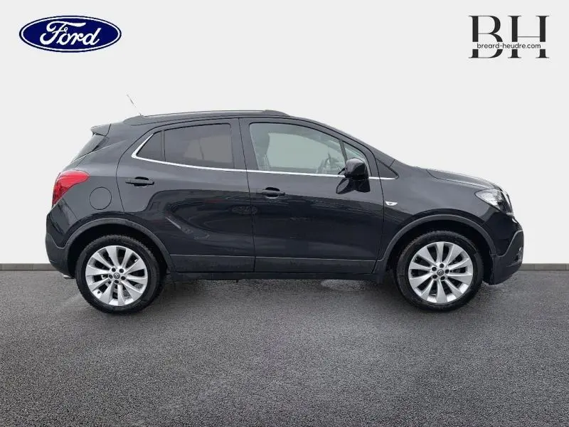 Profil droit d'un Opel Mokka noir carbone de 2016, avec jantes alu et vitres teintées, sur fond neutre.