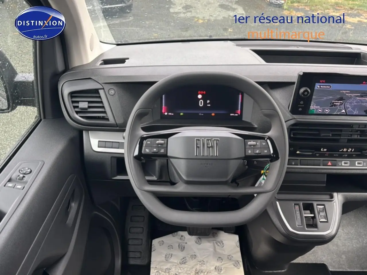 Vue intérieure centrée sur le volant et tableau de bord du Fiat Scudo Combi noir avec écran tactile et commandes au volant.