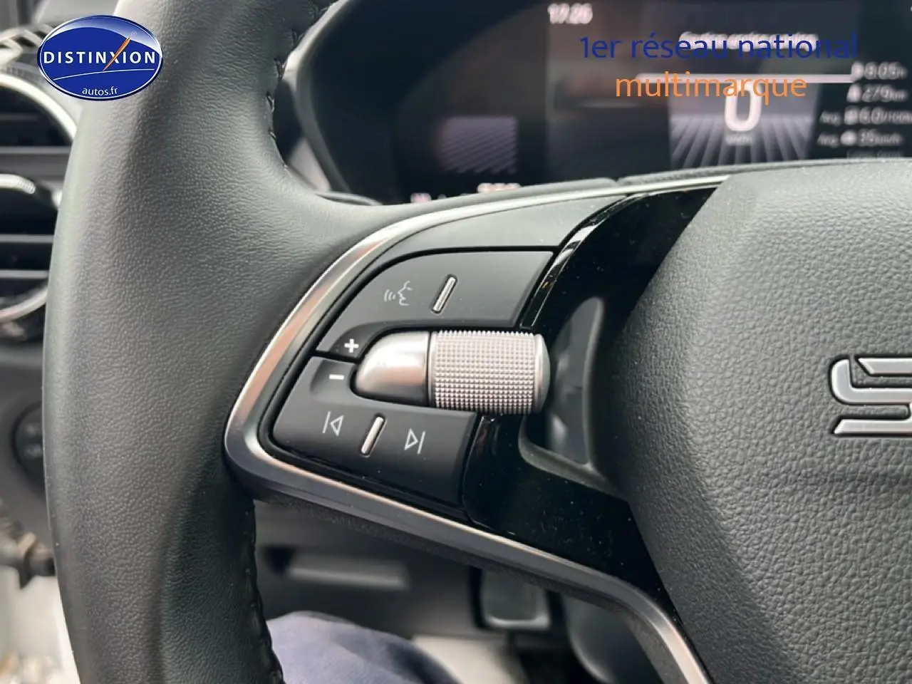 Gros plan sur les commandes audio au volant cuir noir de la Skoda Fabia blanche 2025, version 1.0 TSI Evo2.