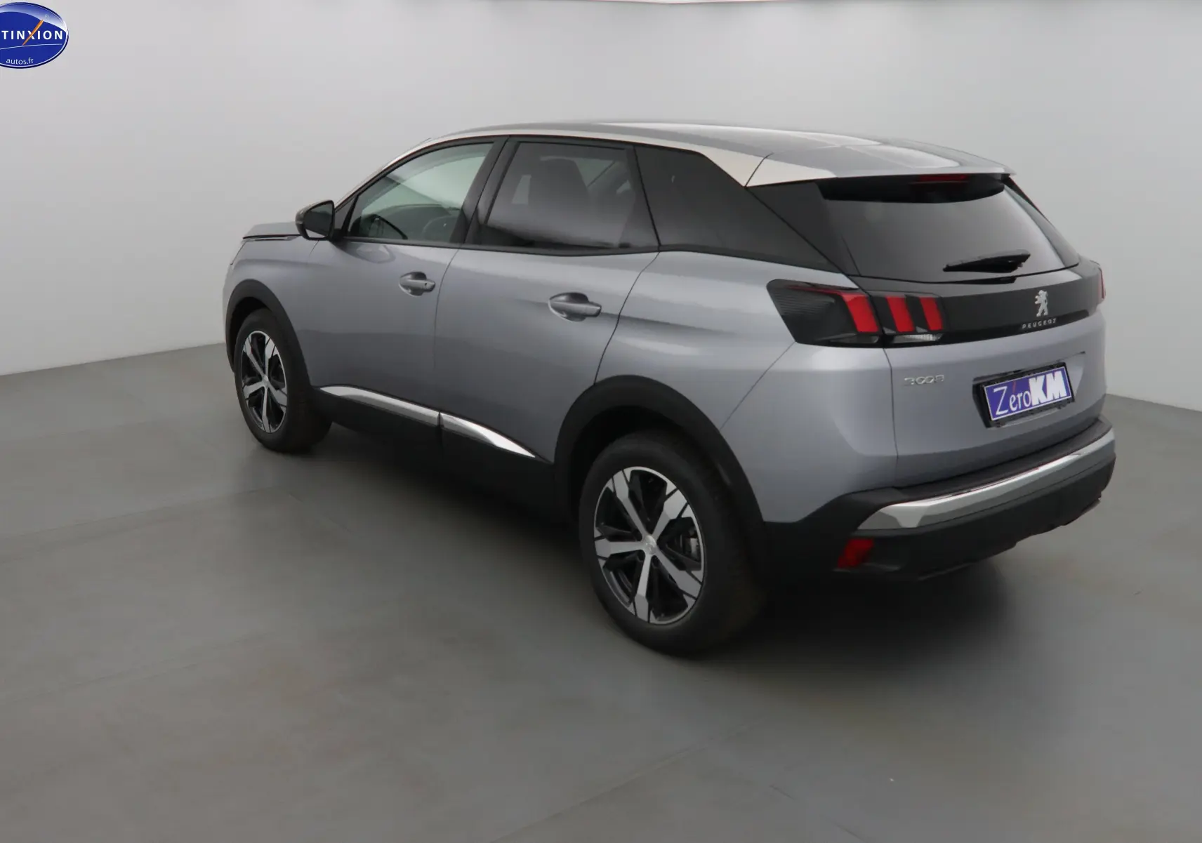 Peugeot 3008 gris Artense métal vue 3/4 arrière côté gauche, avec feux arrière à griffes rouges et toit noir contrasté.