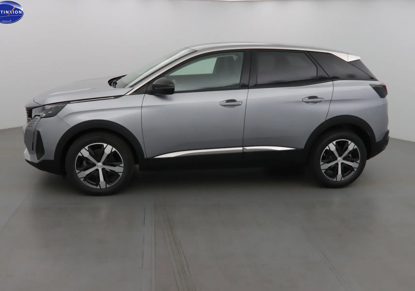 Profil côté gauche du Peugeot 3008 gris Artense métal 2023 avec toit blanc et jantes bi-ton distinctives.