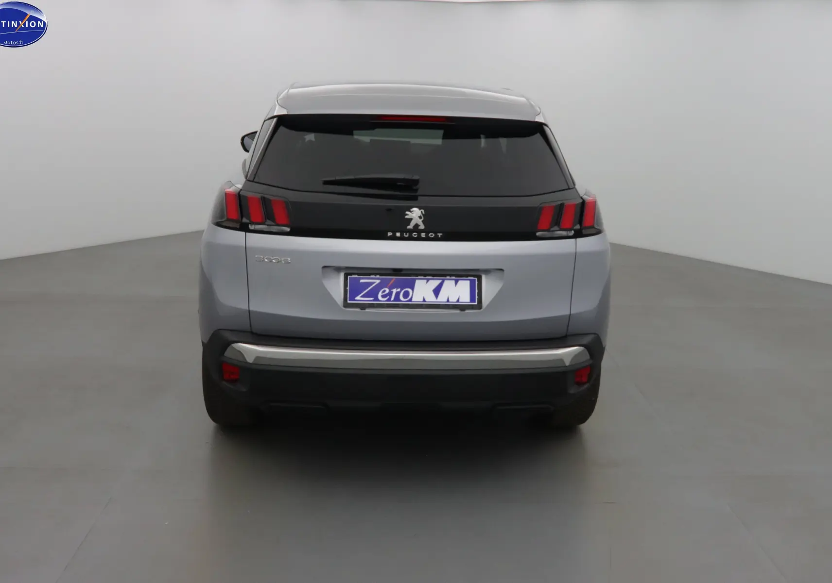 Vue arrière d'un Peugeot 3008 gris Artense métallisé avec feux arrière à griffes et hayon fermé.