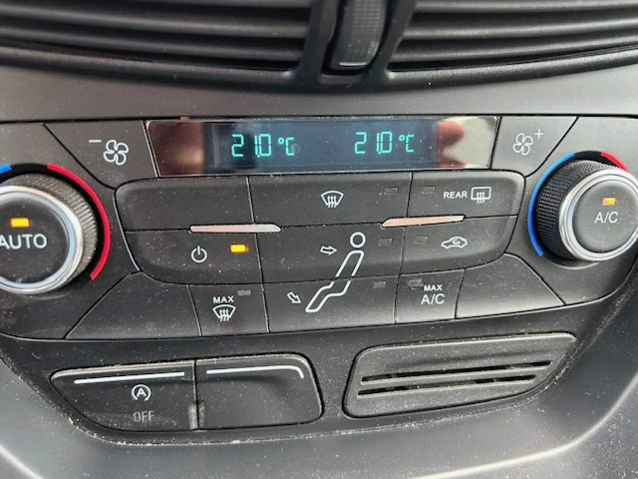Panneau de commande de la climatisation bi-zone du Ford C-MAX gris clair, affichant 21°C des deux côtés.