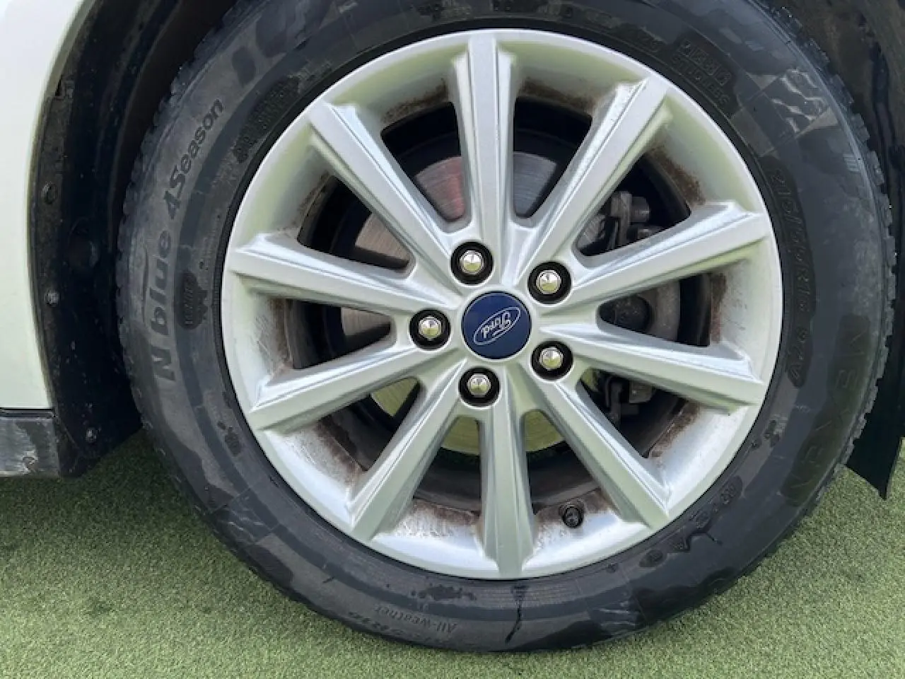 Gros plan sur la jante alliage 16 pouces 10 branches et pneu toutes saisons d'une Ford C-MAX gris clair métal.