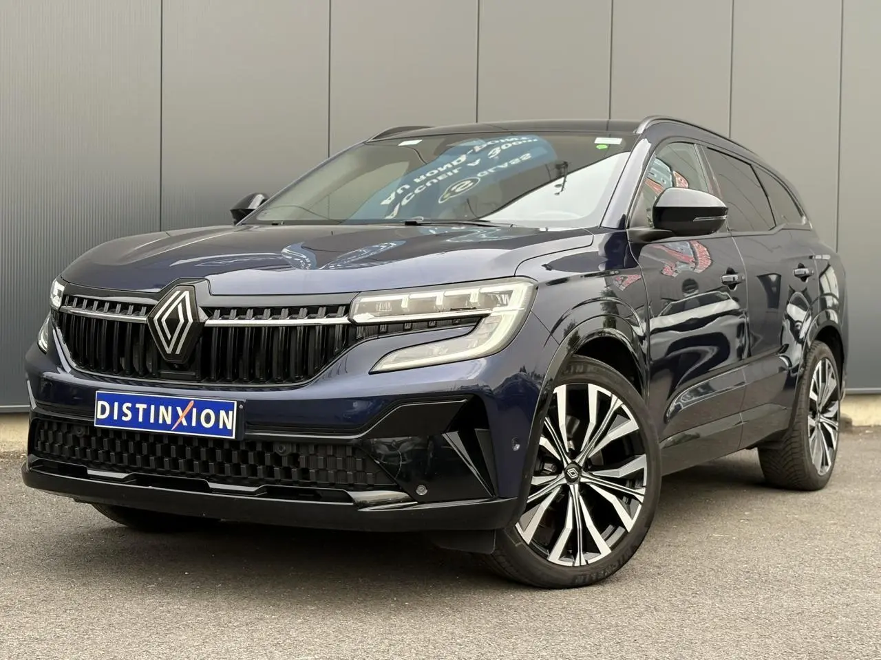 Renault Espace VI bleu nuit en 3/4 avant droit, avec calandre noire et jantes alliage diamantées 20 pouces.