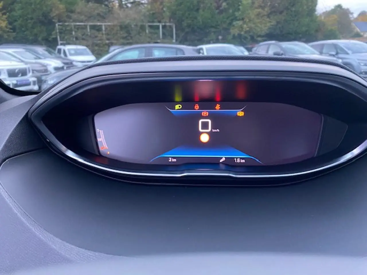 Tableau de bord numérique du Peugeot 5008 2023 affichant la vitesse et témoins lumineux, vue frontale rapprochée.