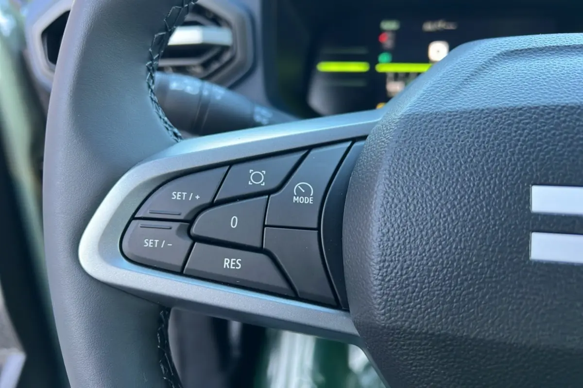 Gros plan sur les commandes au volant du Dacia Duster 2025, version Mild Hybrid 130 4x4 Expression, avec volant cuir noir.