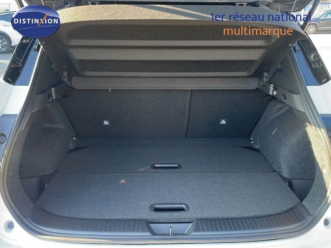 Coffre ouvert vue arrière d'un Nissan Qashqai blanc nacré avec intérieur de coffre noir et plancher plat.