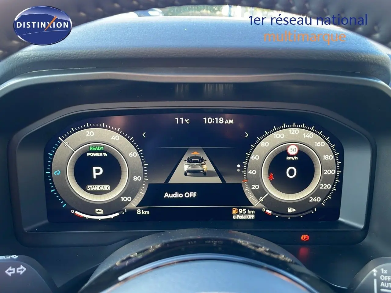 Tableau de bord numérique du Nissan Qashqai 2025 affichant la vitesse, la puissance et l'autonomie, vue de face depuis le poste de conduite.