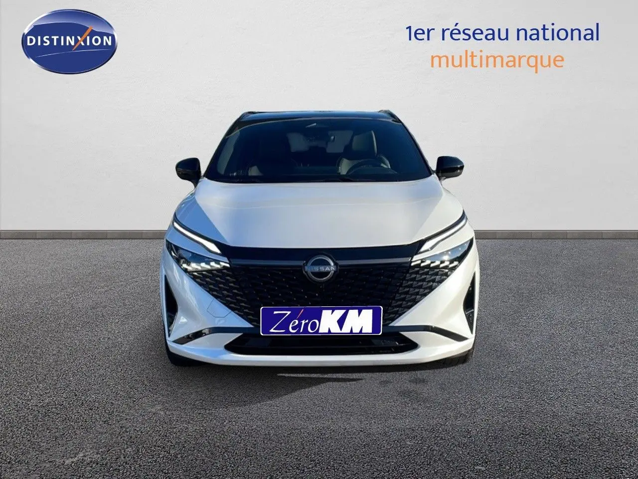 Vue frontale d'un Nissan Qashqai blanc nacré avec toit noir, calandre noire et feux LED fins.