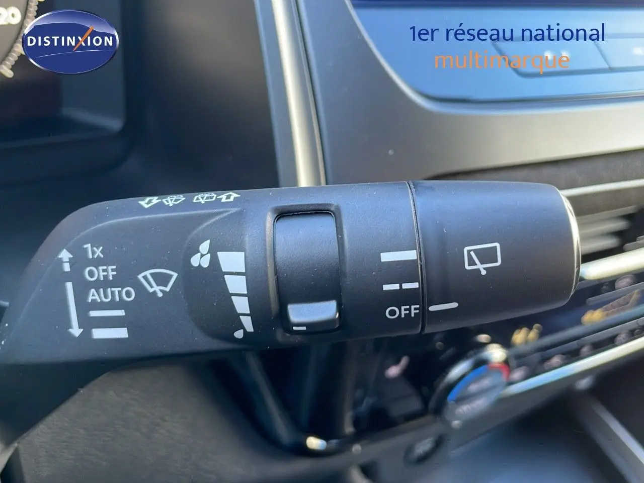 Gros plan sur la commande d'essuie-glace du Nissan Qashqai blanc nacré 2025 avec toit noir, intérieur moderne.