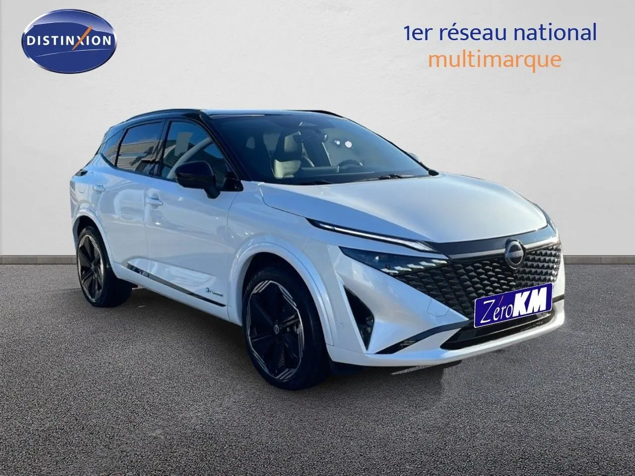 Nissan Qashqai blanc nacré avec toit noir, vue 3/4 avant droit mettant en valeur sa calandre distinctive et ses jantes noires.