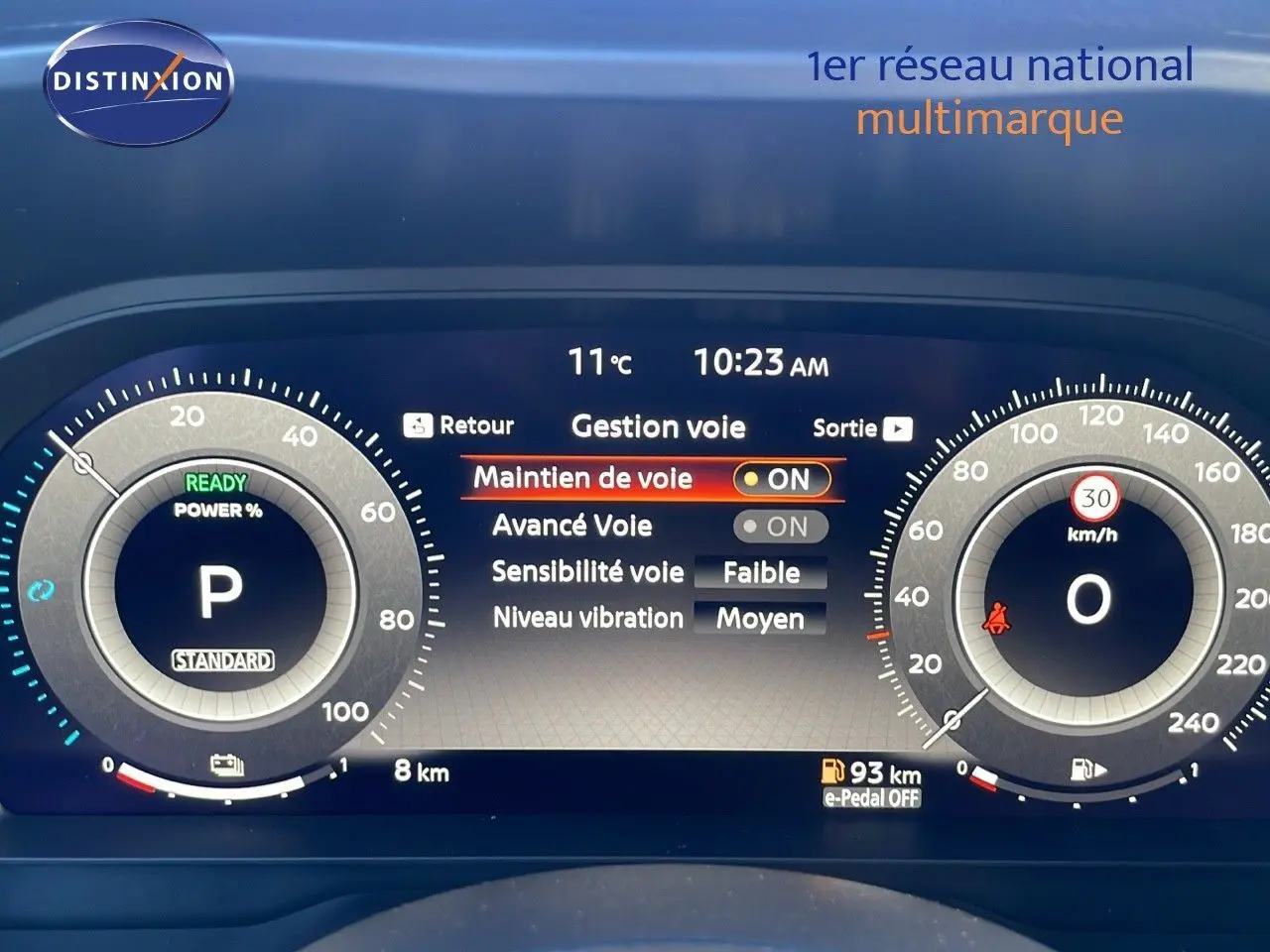 Tableau de bord numérique du Nissan Qashqai blanc nacré, affichant les réglages du maintien de voie et la vitesse à 0 km/h.