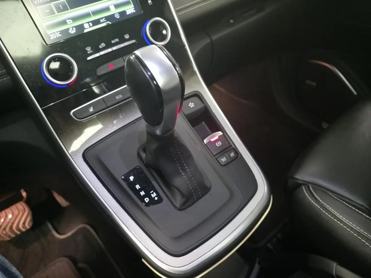 Gros plan sur la console centrale noire du Renault Scénic 2018 avec levier de boîte automatique et commandes éclairées