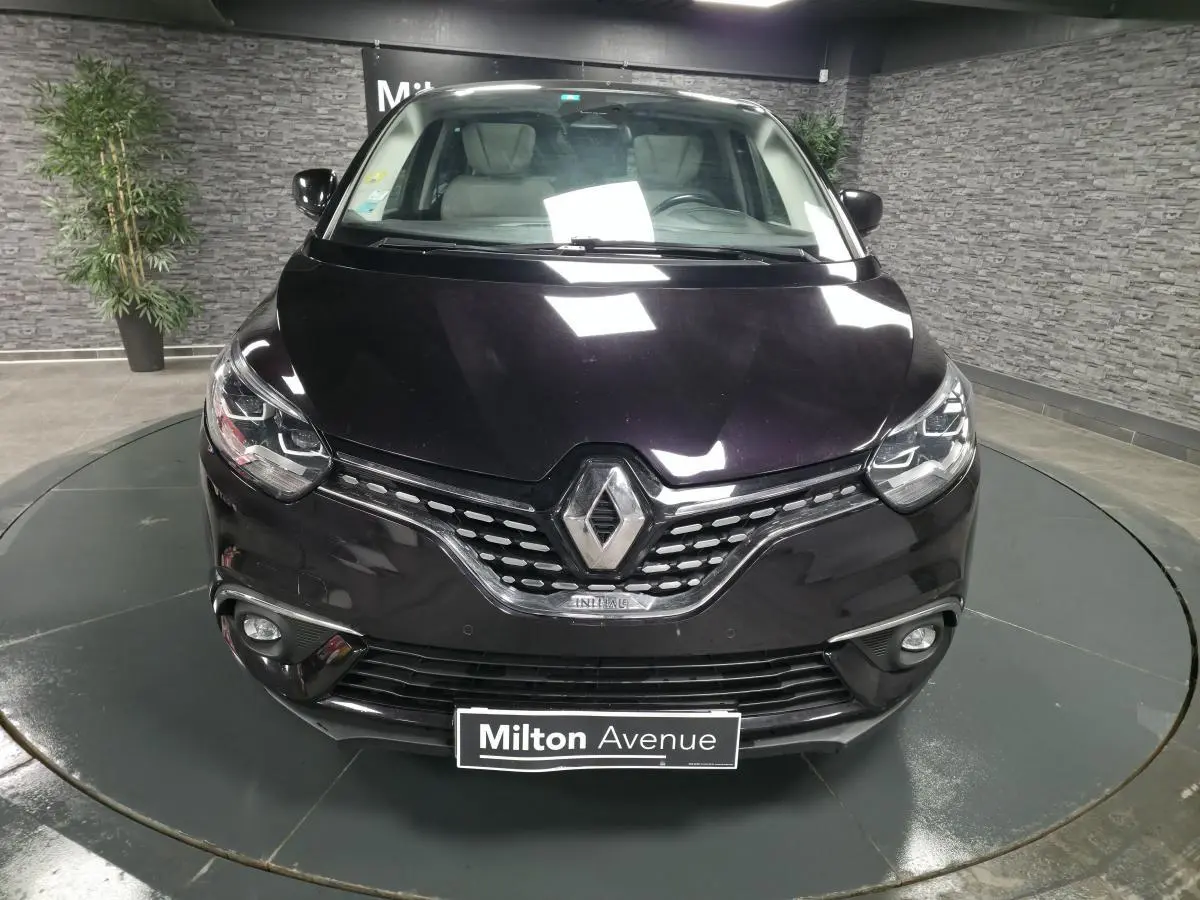Vue de face d'un Renault Scénic noir Améthyste avec calandre chromée et phares Full LED dans un showroom.