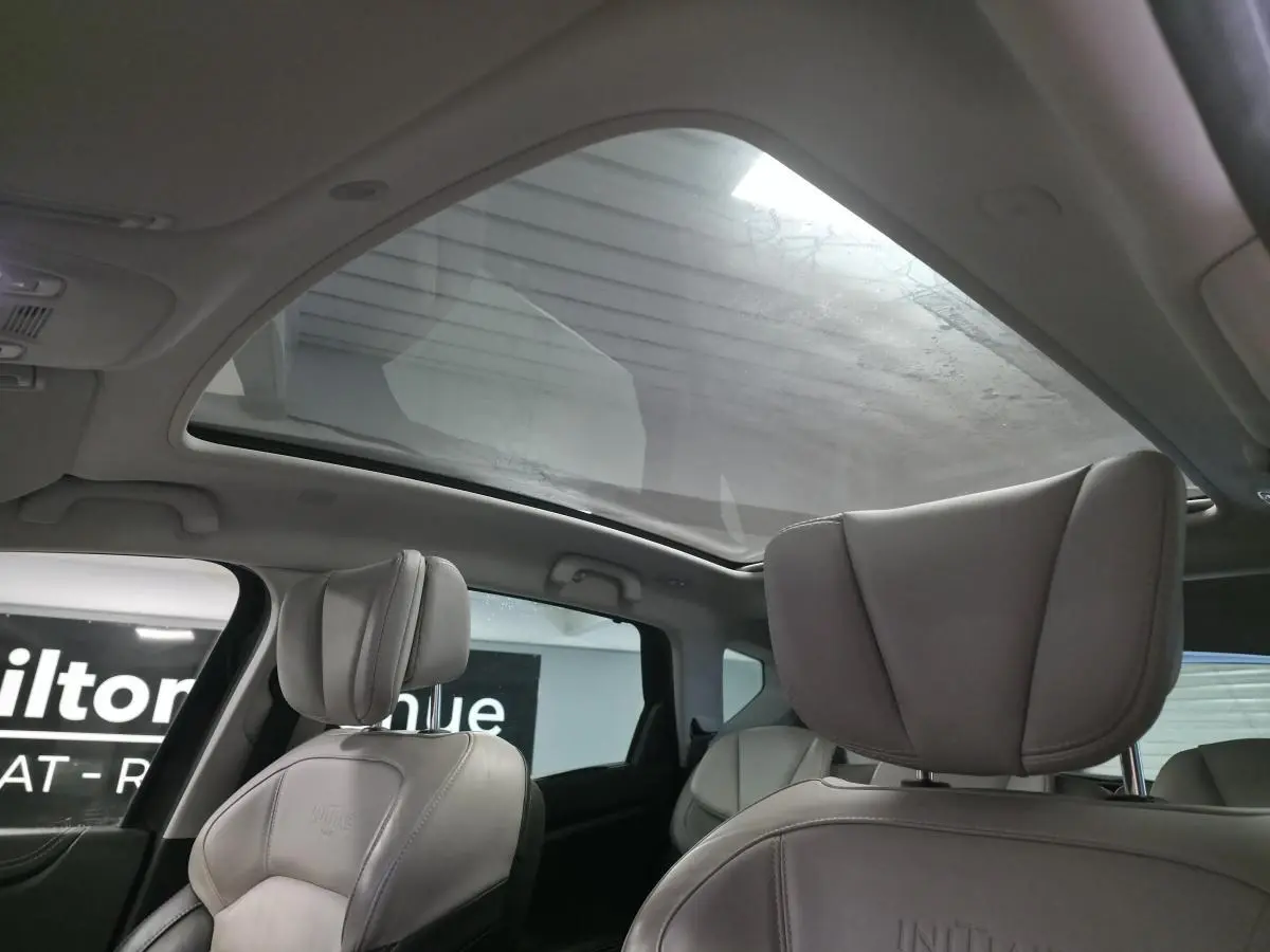 Vue intérieure du Renault Scenic 2018 montrant les sièges cuir gris et le toit panoramique en verre fixe.
