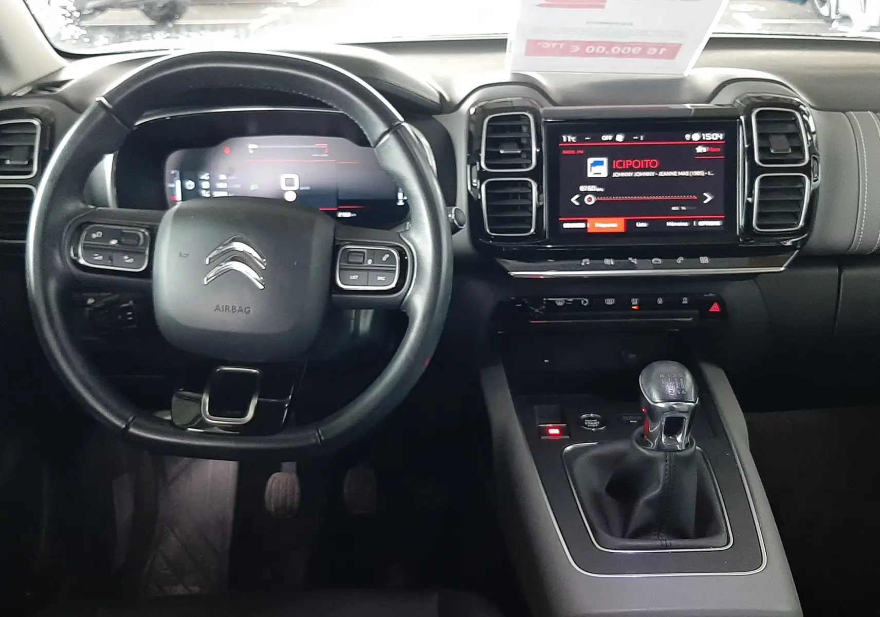 Vue intérieure frontale du tableau de bord et volant du Citroën C5 Aircross gris avec boîte manuelle et écran tactile central.