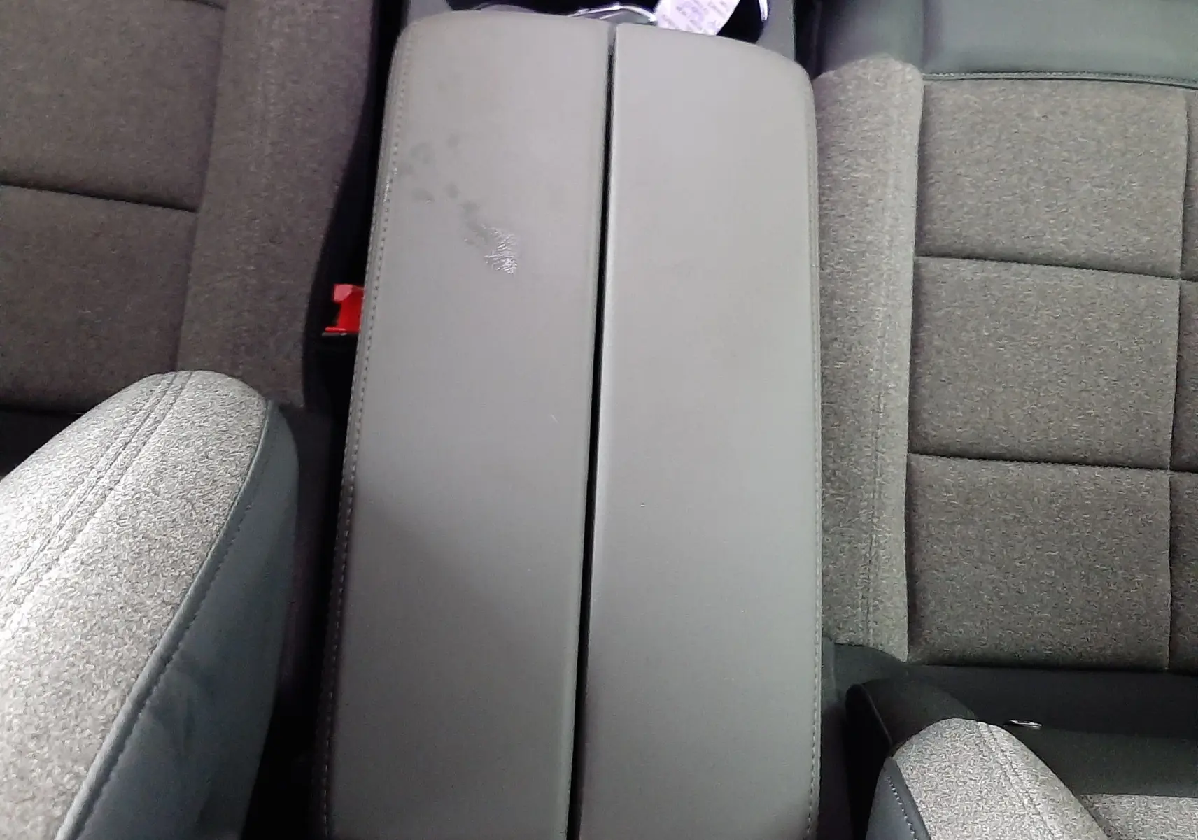 Vue plongeante sur l'accoudoir central gris clair et les sièges tissu gris du Citroën C5 Aircross 2021.