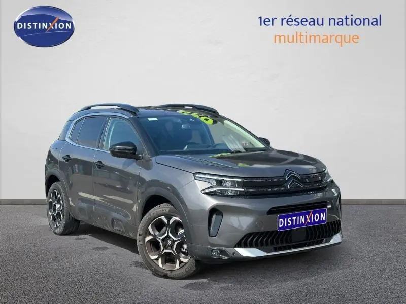 Vue 3/4 avant du Citroën C5 Aircross gris Platinium 2025 avec calandre distinctive et jantes alliage bicolores.