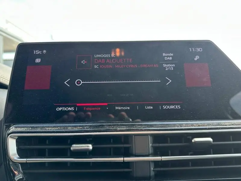Écran tactile central du tableau de bord du Citroën C5 Aircross 2025 affichant la radio DAB sur fond noir avec commandes tactiles.