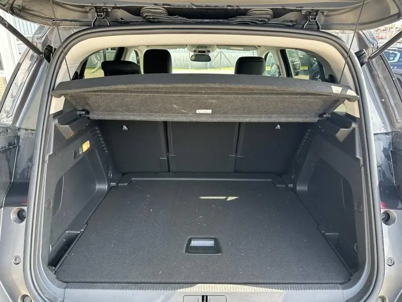 Vue arrière du coffre ouvert du Citroën C5 Aircross gris Platinium 2025, montrant un espace de chargement spacieux et propre.