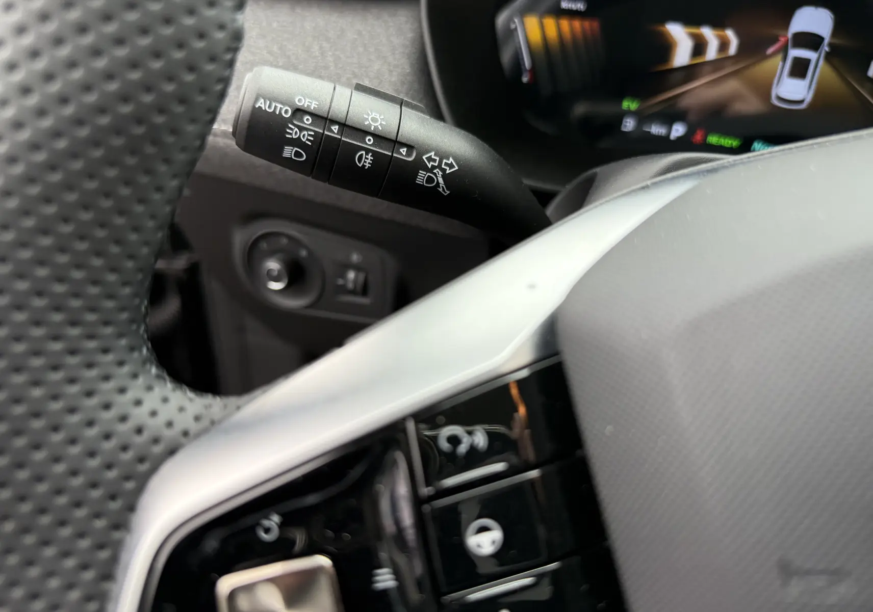 Gros plan sur la manette de clignotants et les commandes au volant du MG ZS 1.5L Hybrid+ 2026, intérieur noir.
