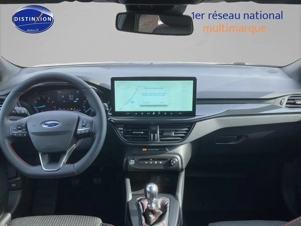 Vue intérieure avant de la Ford Focus gris, volant 3 branches avec coutures rouges et écran tactile central 13,2 pouces.